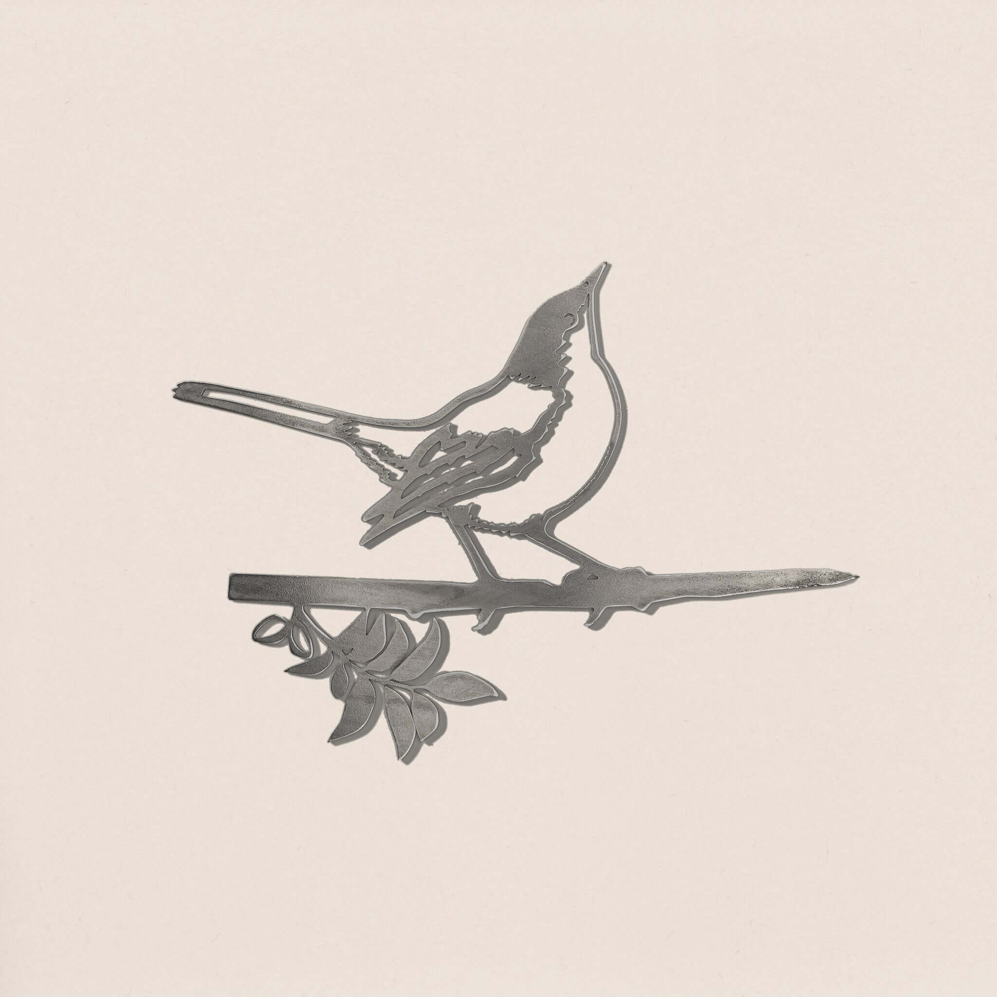 Mockingbird is a premium metal silhouette featuring a bird perched on a leafy branch against a light background. Its simple, elegant design makes it perfect yard art.