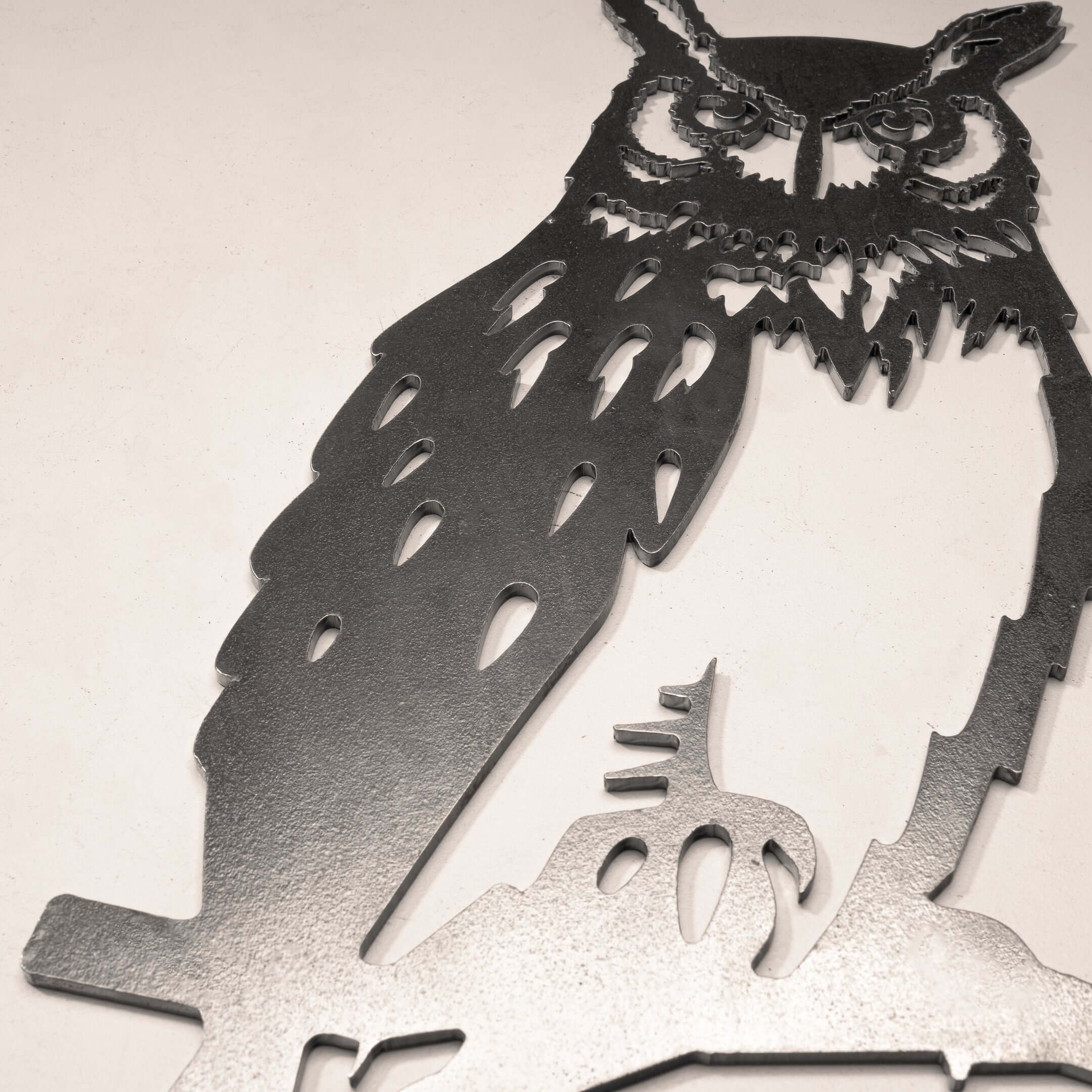 Close-up of Great Horned Owl silhouette in raw Corten steel, showcasing bold craftsmanship for striking garden art or memorial decor.