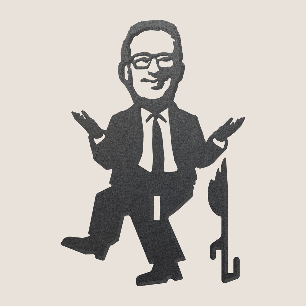 A black silhouette illustration of Pūteketeke's Friend—a person in a suit and glasses, smiling and shrugging next to a cane and tail or flame—captures the premium metal art style on a plain light background.