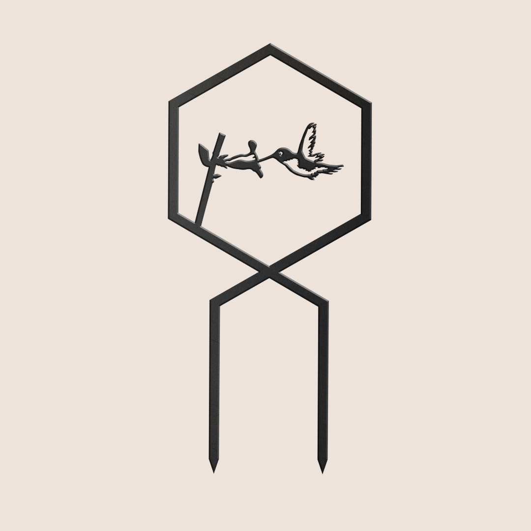 The Hummingbird Plant Trellis is a minimalist black metal garden stake featuring a hexagon with a hummingbird feeding from a flower, creating an elegant accent against any light background.