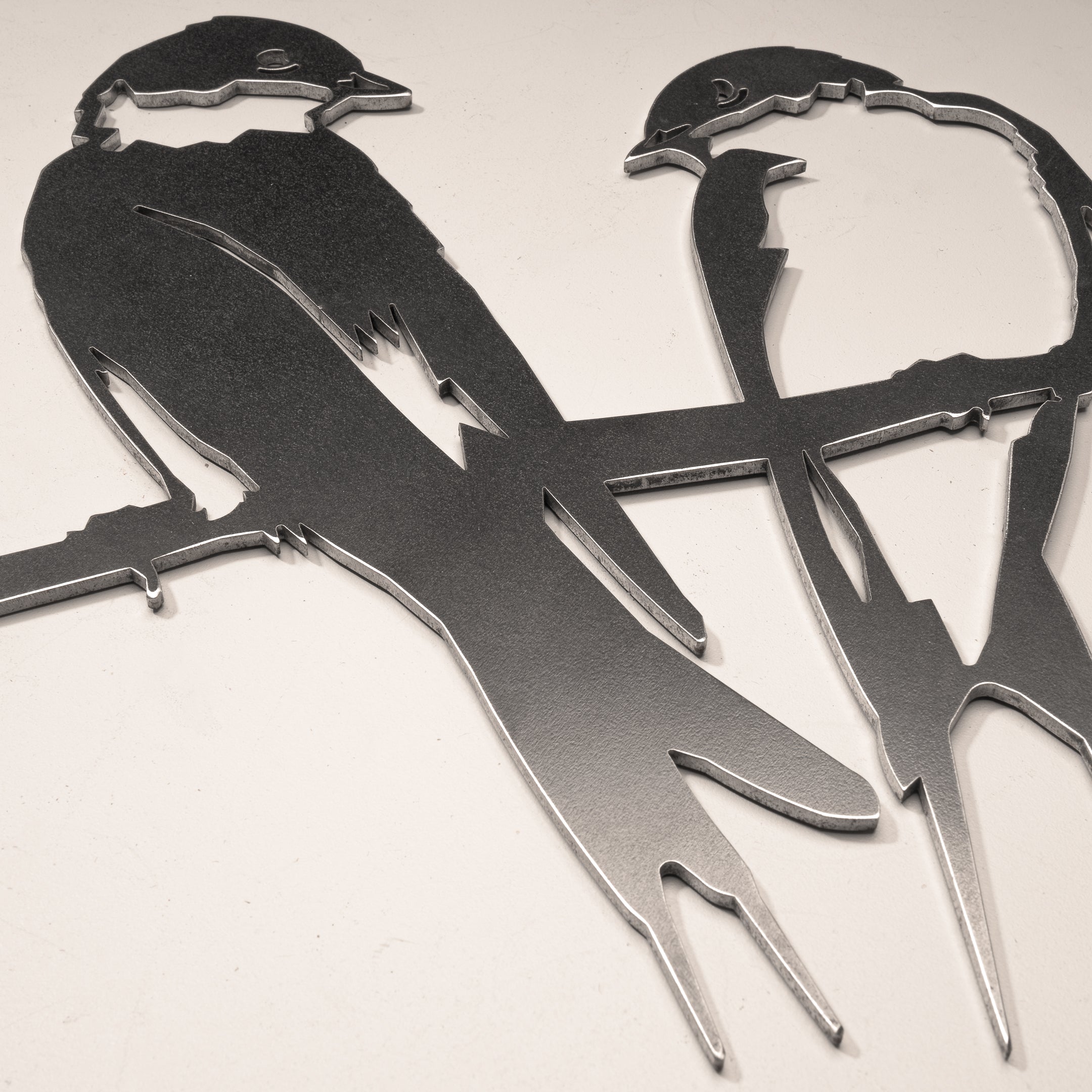 Pair of Swallows metal wall art features two stylized birds on a branch, crafted from corten steel with geometric lines and a sleek surface—a stylish gift or unique yard decor for any space.