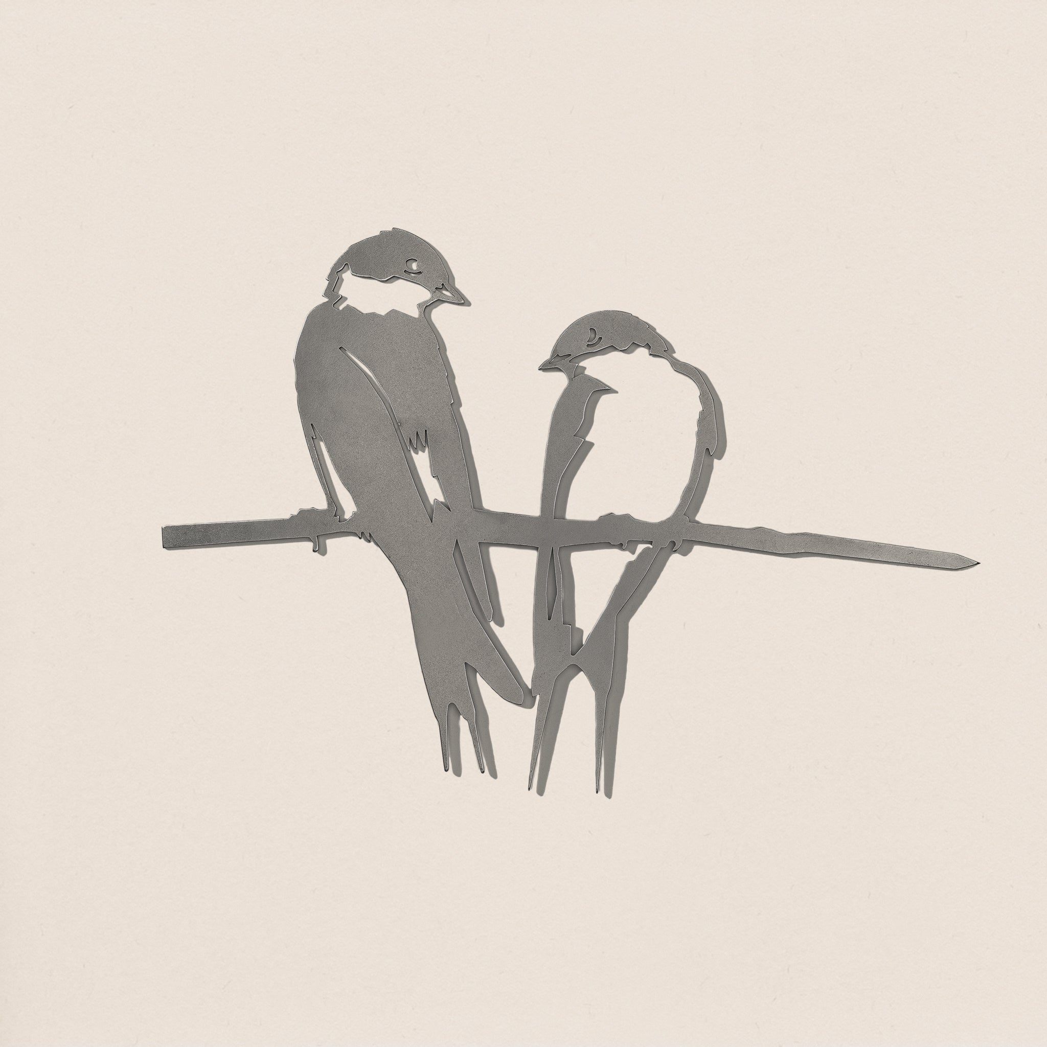 A minimalist grayscale illustration titled "Pair of Swallows" features two small birds perched closely on a bare branch, evoking the refined simplicity of premium yard art reminiscent of sculpted corten steel against a plain background.
