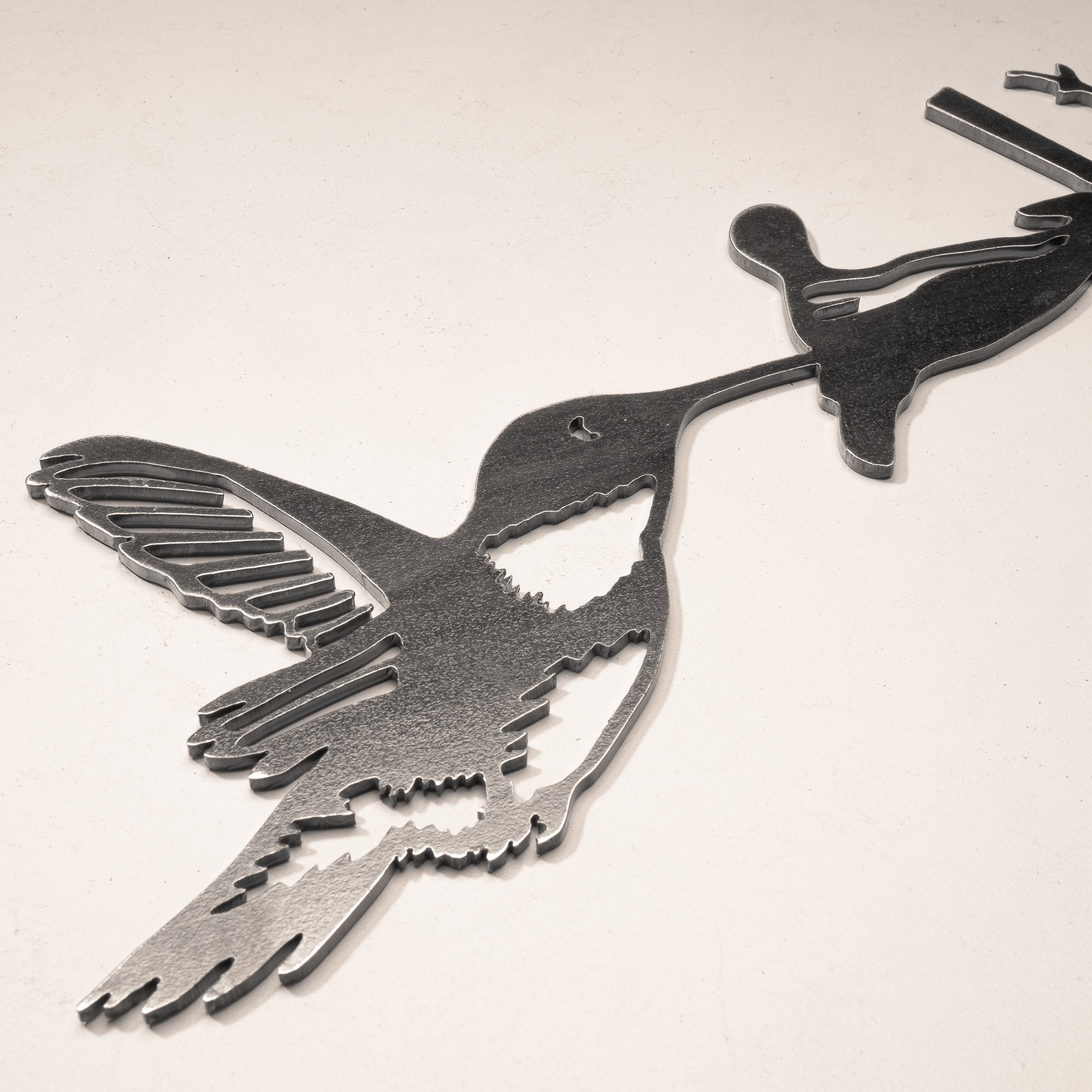 Close-up of Hummingbird silhouette in raw Corten steel. Precision-cut garden art. Stunning gift for nature and bird lovers
