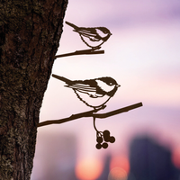 The Chickadee Mom & Mini Set features two silhouetted birds on branches at sunset, with berries and a blurred cityscape—crafted from Corten steel, it's perfect garden decor and a thoughtful gift for bird lovers.