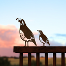 The Quail Mom & Mini Set features two Corten steel California quail silhouettes on a fence rail, set against a sunset sky—an ideal Mother's Day gift and unique decor for any outdoor space.