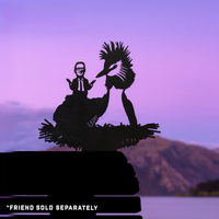 A black silhouette of a person in a suit sits on the back of a large Pūteketeke (Crested Grebe) in a nest, with a purple sky and mountains behind. Text below reads: FRIEND SOLD SEPARATELY.