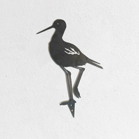 The Metalbird Seconds - Black Stilt features a striking metal bird with a long beak standing on one leg. As part of our exclusive seconds collection, this piece may have minor cosmetic imperfections.
