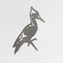 A Metalbird Seconds - Pileated Woodpecker features a premium metallic silhouette in profile, highlighting its crest and pointed beak, mounted on a white textured wall—an elegant gift for nature lovers.