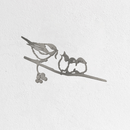 Metalbird Seconds - Chickadee & Chicks features a corten steel silhouette of a bird feeding two chicks on a branch with berries, displayed on a white textured wall.