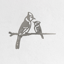 The Metalbird Seconds - Blue Jay & Chick features two stylized birds with intricate cut-out details, crafted from corten steel and mounted on a white textured wall. The larger blue jay faces the smaller chick, creating striking metal wall art.