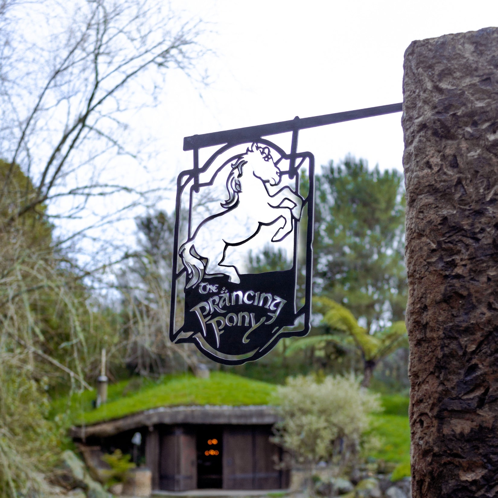 Full scene view of The Prancing Pony sculpture outdoors mounted on post or deck.