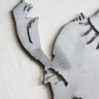 Close-up of the Metalbird Seconds - Cardinal, a premium gray metal wall art piece featuring a stylized cardinal silhouette with sharp accents, displayed on a textured white wall.
