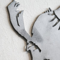 Close-up of Metalbird Seconds - Canada Jay, a gray metal wall art piece shaped like a Canada Jay, mounted on a textured white wall; part of the Seconds collection and may have subtle cosmetic imperfections.