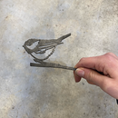 A hand holds the Chickadee Mom & Mini Set—a thin metal cutout of a bird and chick on a branch, perfect as Corten steel garden decor or a gift for bird lovers—displayed against a plain, light gray background.