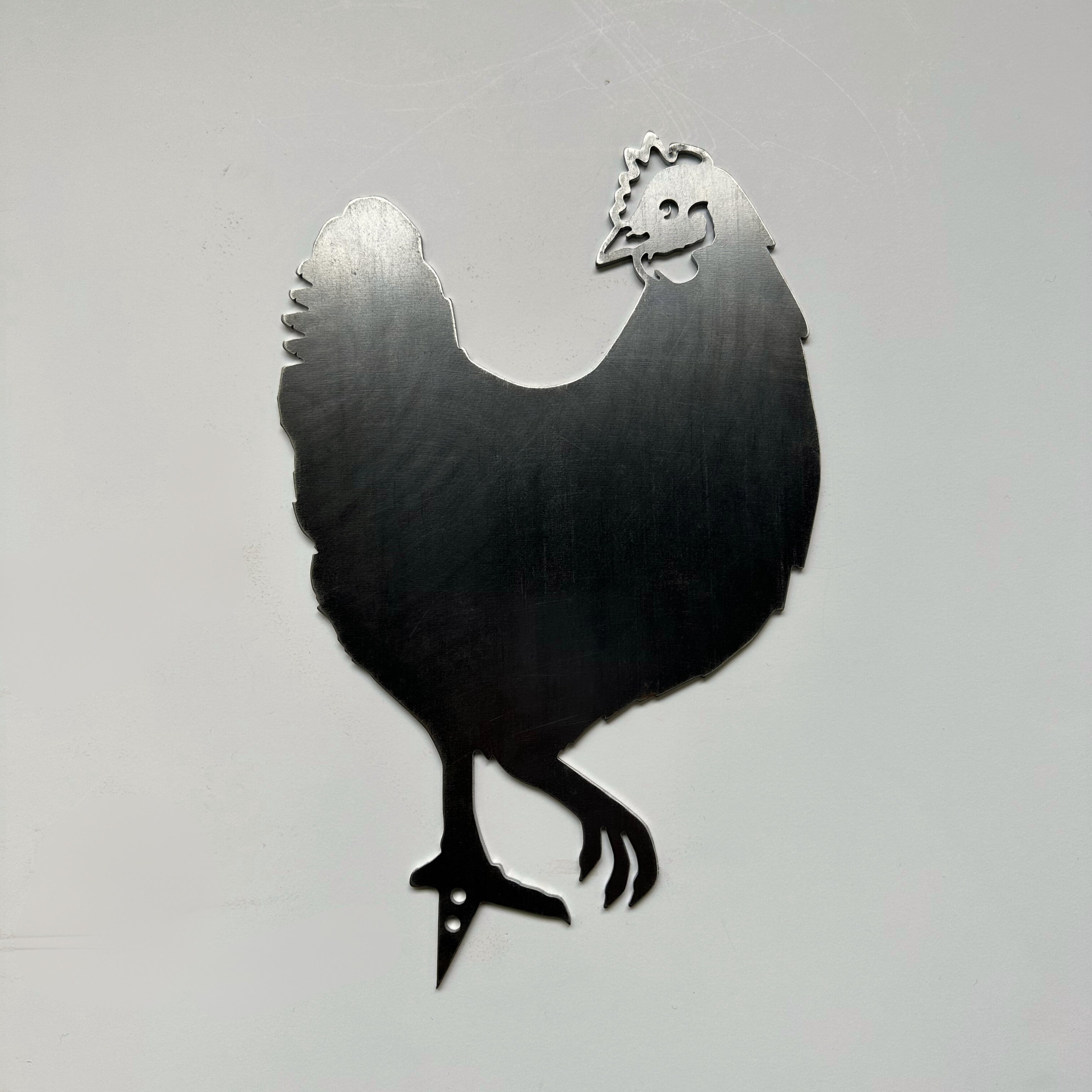 The Rhode Island Red is a metal silhouette cutout of the state bird, standing on one leg against a plain light gray background.