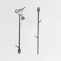 Minimalist wall art featuring two black branches: the left branch has a Chickadee, inspired by the Metalbird Seconds - Chickadee Plant Stake, perched on top with berries below; the right branch is bare, set against a plain white background.