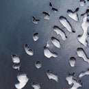 Close-up of the Metalbird Seconds - Chickadee & Chicks, featuring a dark, textured corten steel surface with organic cutouts revealing a lighter background—an abstract piece ideal for unique yard art or a thoughtful gift.