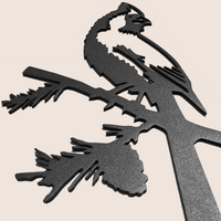 Cardinal Black features a powder-coated black metal silhouette of a cardinal perched on a branch, with intricate pine needle and pinecone cutouts, displayed against a light beige background.