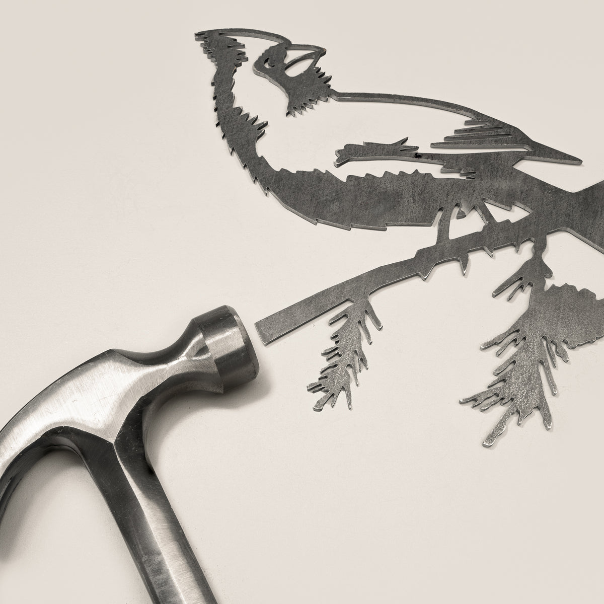 Cardinal steel silhouette beside a hammer.
