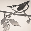 The "Nuthatch" metal wall art features a nuthatch perched on a leafy branch against a light background—a perfect tribute to backyard birds.