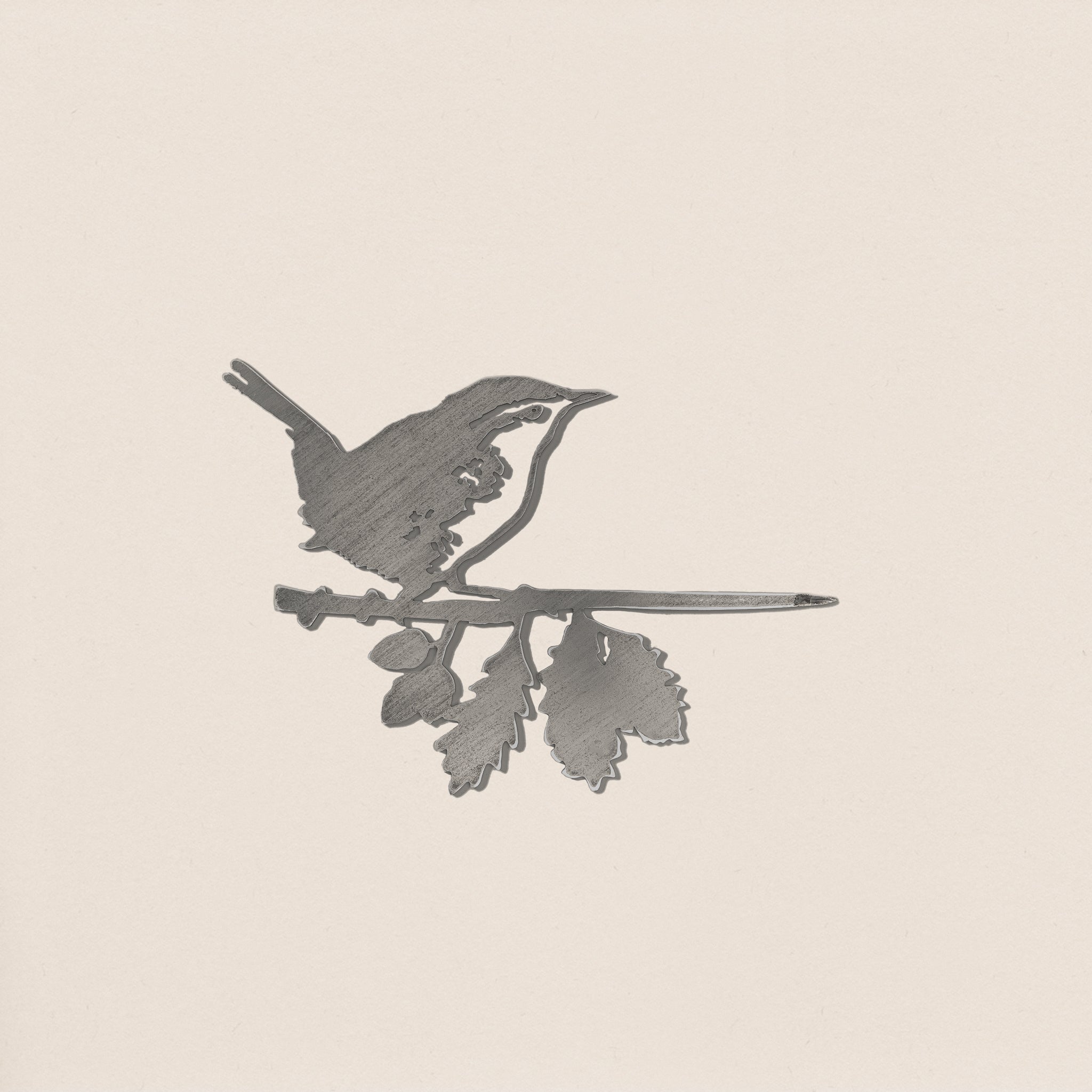 A metallic pencil engraving-style illustration of a wren perched on a leafy branch against a light background—ideal inspiration for corten steel yard art.