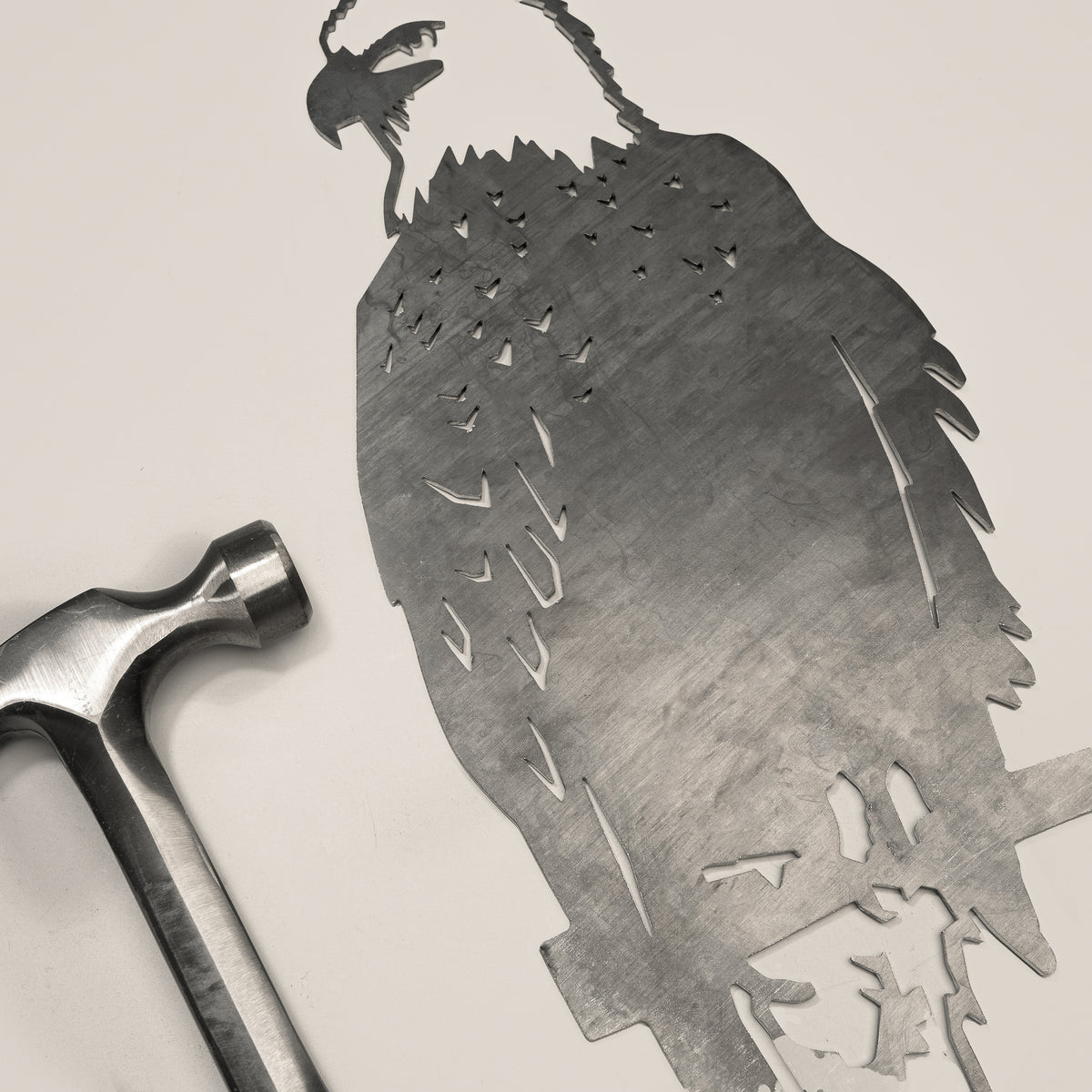 Bald Eagle steel silhouette beside a hammer.