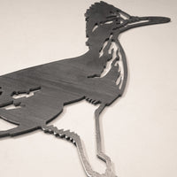 The Road Runner is a geometric, stylized metal wall art sculpture crafted from Corten steel. Highlighting the bird’s crest, beak, and long legs, this outdoor decor features angular lines and looks striking on a light-colored wall.