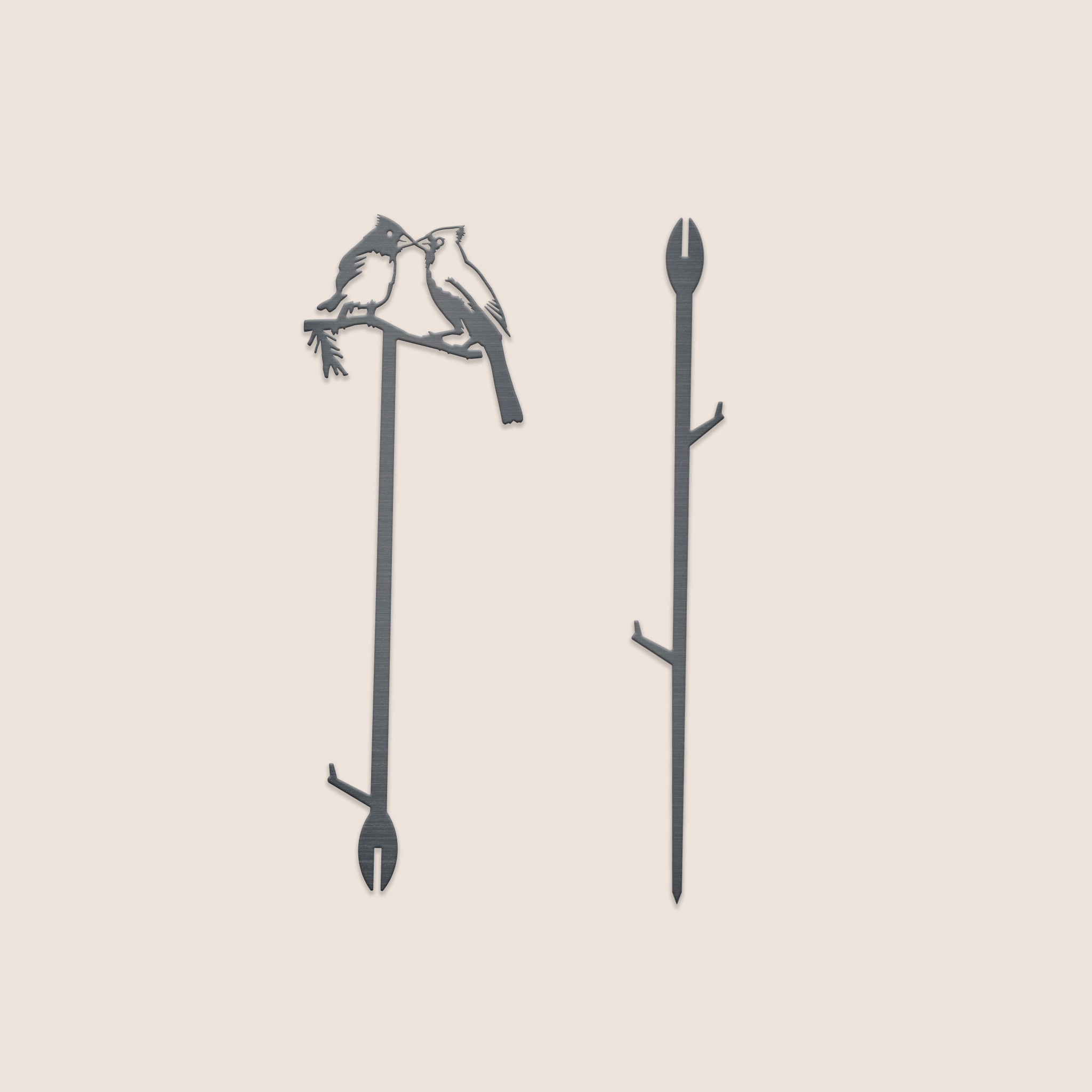 Two metal drink stirrers: one featuring birds on a branch, inspired by the 25" Kissing Cardinals Plant Stake, and one with a simple branch. Both include cut-out details and a slit at the bottom.