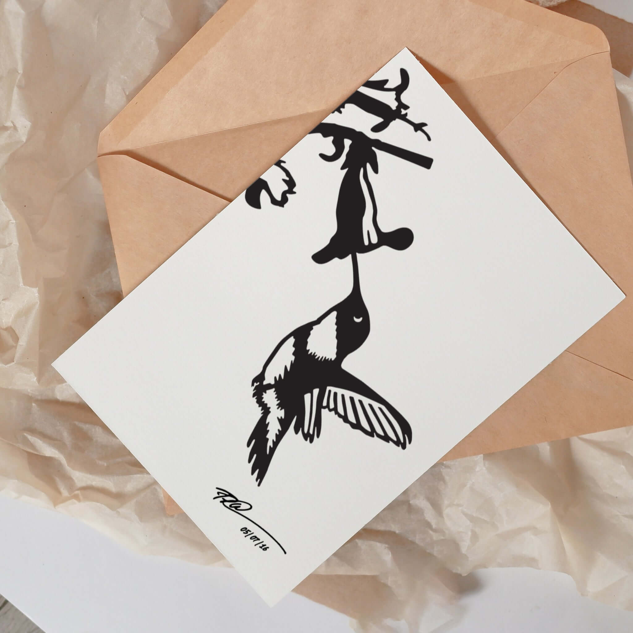 The Metalbird Greeting Card Set features a striking black-and-white bird silhouette feeding from a flower on crumpled brown paper with a light brown envelope—ideal inspiration for nature-themed yard art.