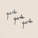 Three black hummingbird silhouettes hover near flowers, diagonally arranged on a light beige background. This minimalist design highlights the birds in mid-flight—perfect for the Baby Bird Bundle - Hummingbird Trio.