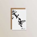 The Metalbird Greeting Card Set features a premium black-and-white silhouette of a hummingbird hovering near a flower, printed on a white card with a brown envelope, set against a light background.