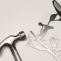 Corten steel hummingbird sculpture shown with a hammer, highlighting easy installation for outdoor garden art lovers in the USA.